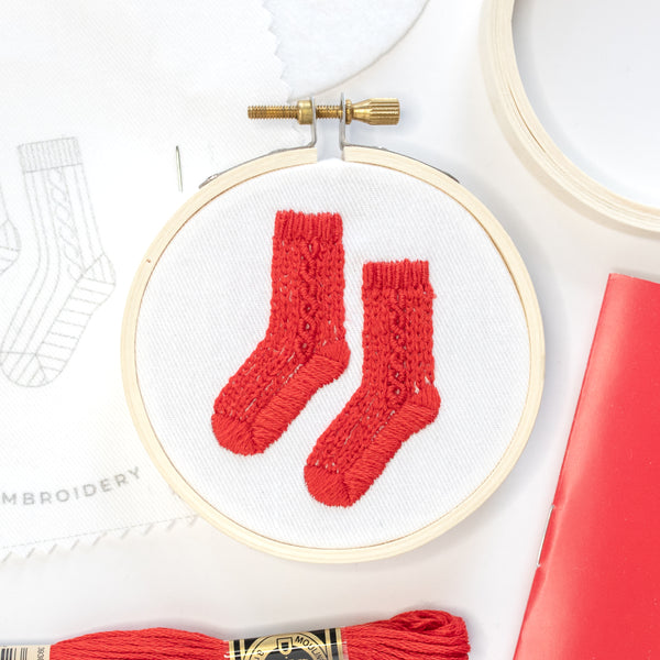 Mini embroidery hoop featuring red knit socks