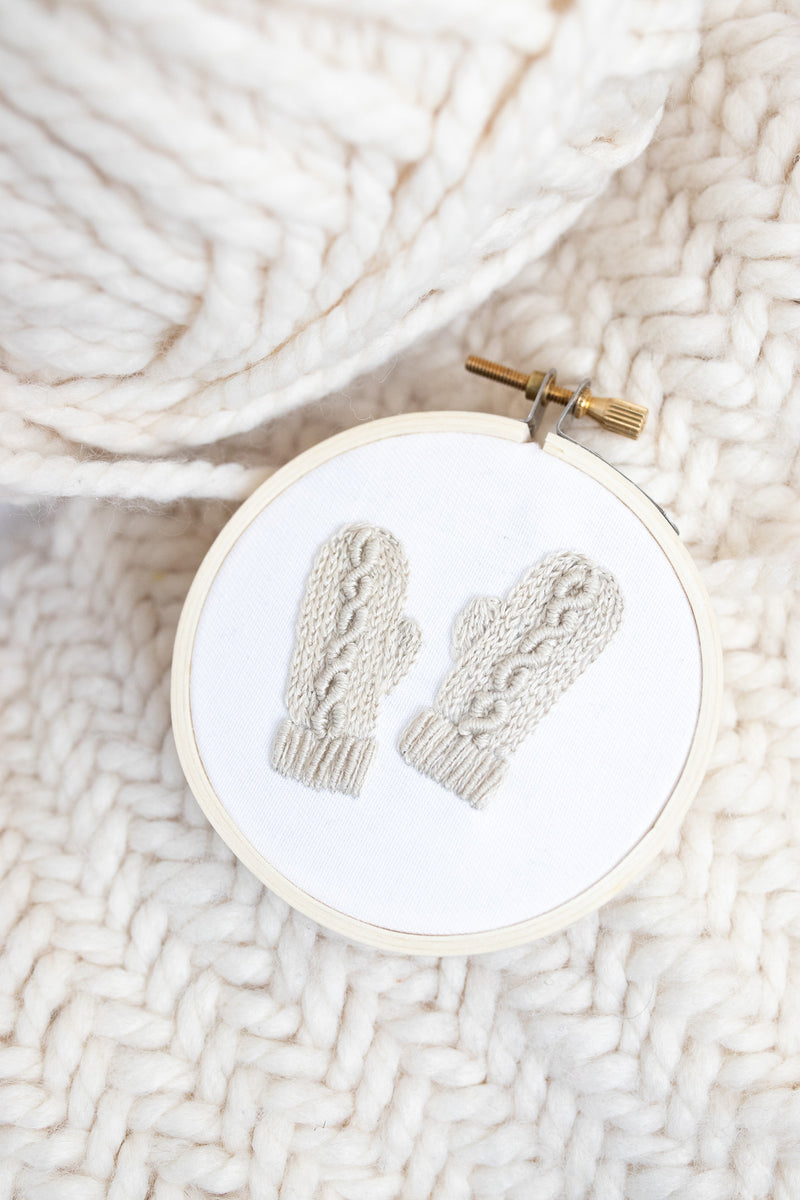 Finished mini embroidery pattern depicting knit gloves