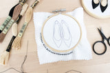 Tools and supplies needed to embroider pair of heels on table