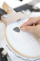 Embroidering a black and white striped pajama top using an embroidery stand