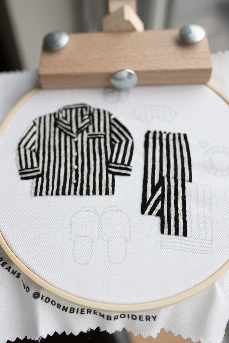 Stitching a black and white striped pajama top using an embroidery stand