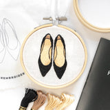 Mini embroidery hoop featuring a pair of black heels